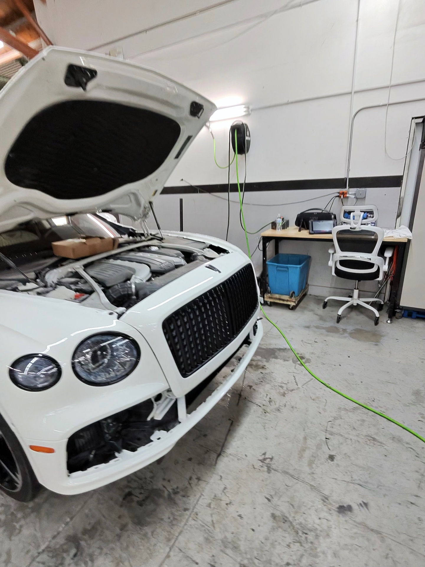 Bentley with the hood open during engine bay service at CarLogic Exotic